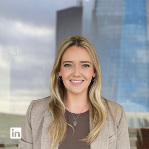 Professional portrait of a smiling woman with blonde hair in a beige blazer, suitable for LinkedIn profile.